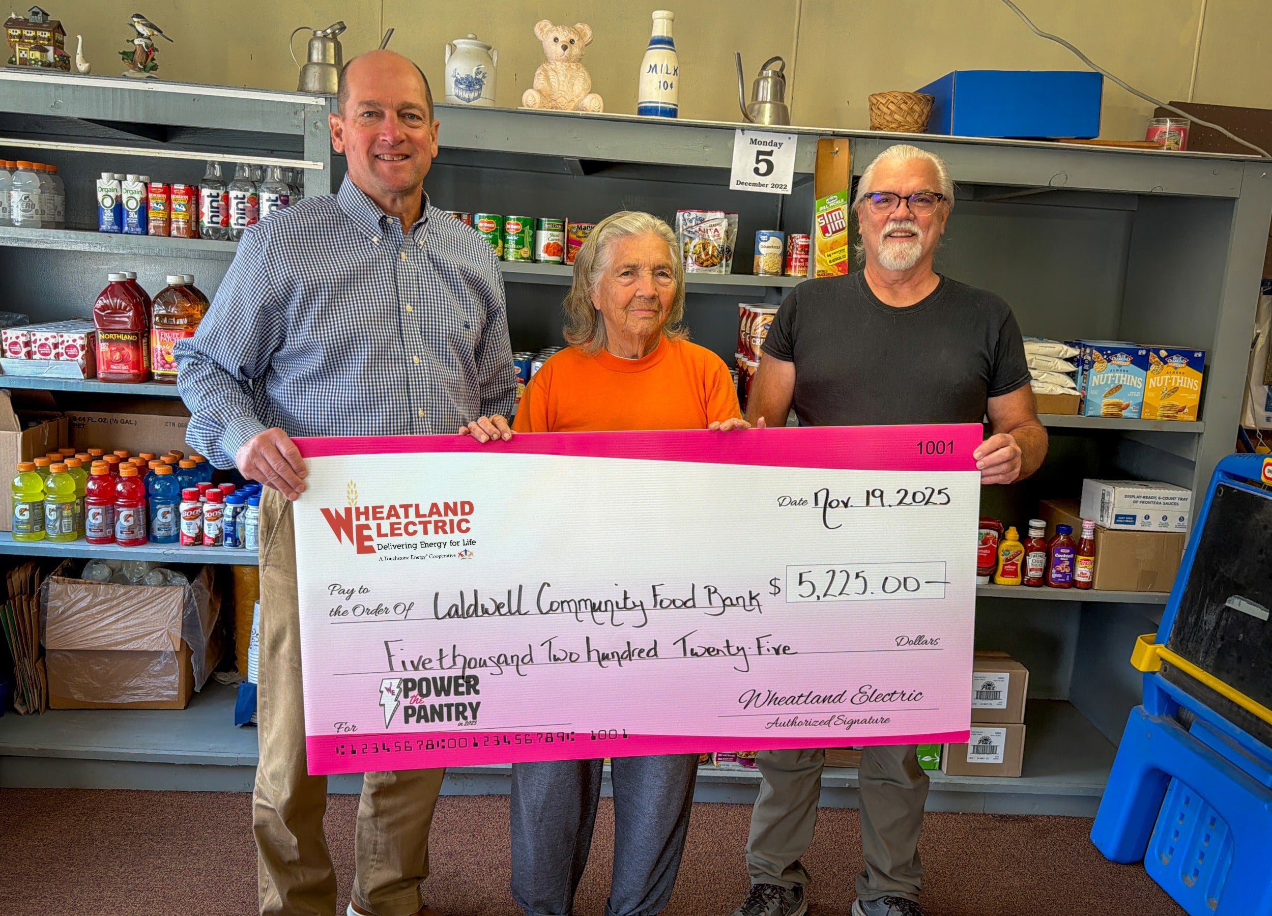 Mark Arnold, Wheatland Electric trustee, presents a check for $5,225 to representatives of the Caldwell Food Bank, including Velta Glenn (middle).