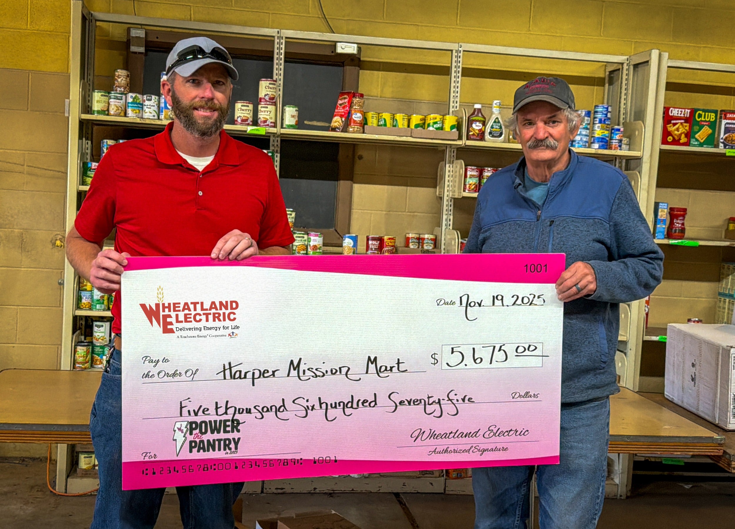 Marcus Goebel (left), WEC district manager, presents a check for $5,675 to Mike Alldritt of the Harper Mission Mart. 