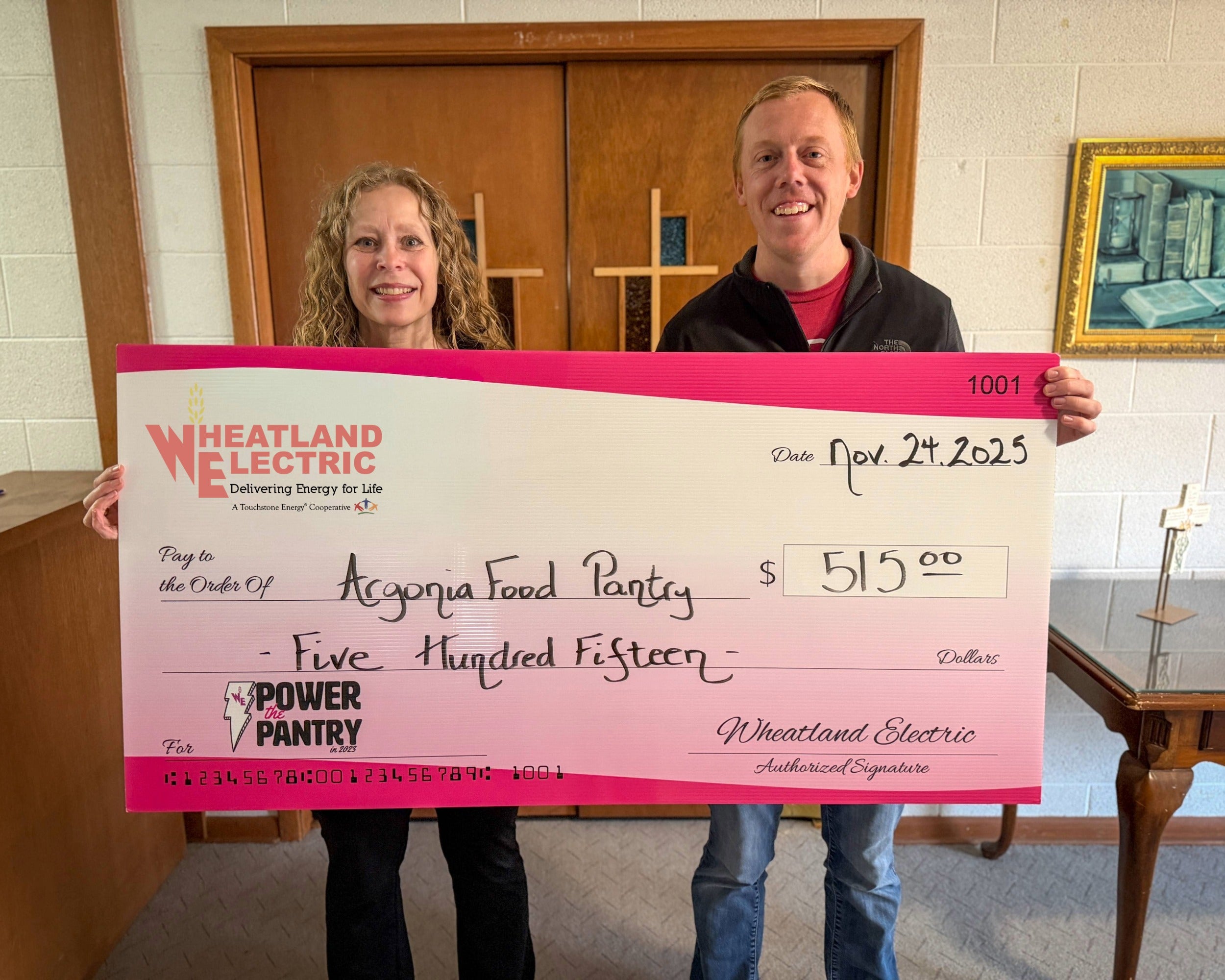 Mary Hoisington, member services and key accounts manager (left), presents a check for $515 to Kirk Taylor, coordinator of the Argonia Ministerial Alliance Food Pantry and a representative of Plains Church. 