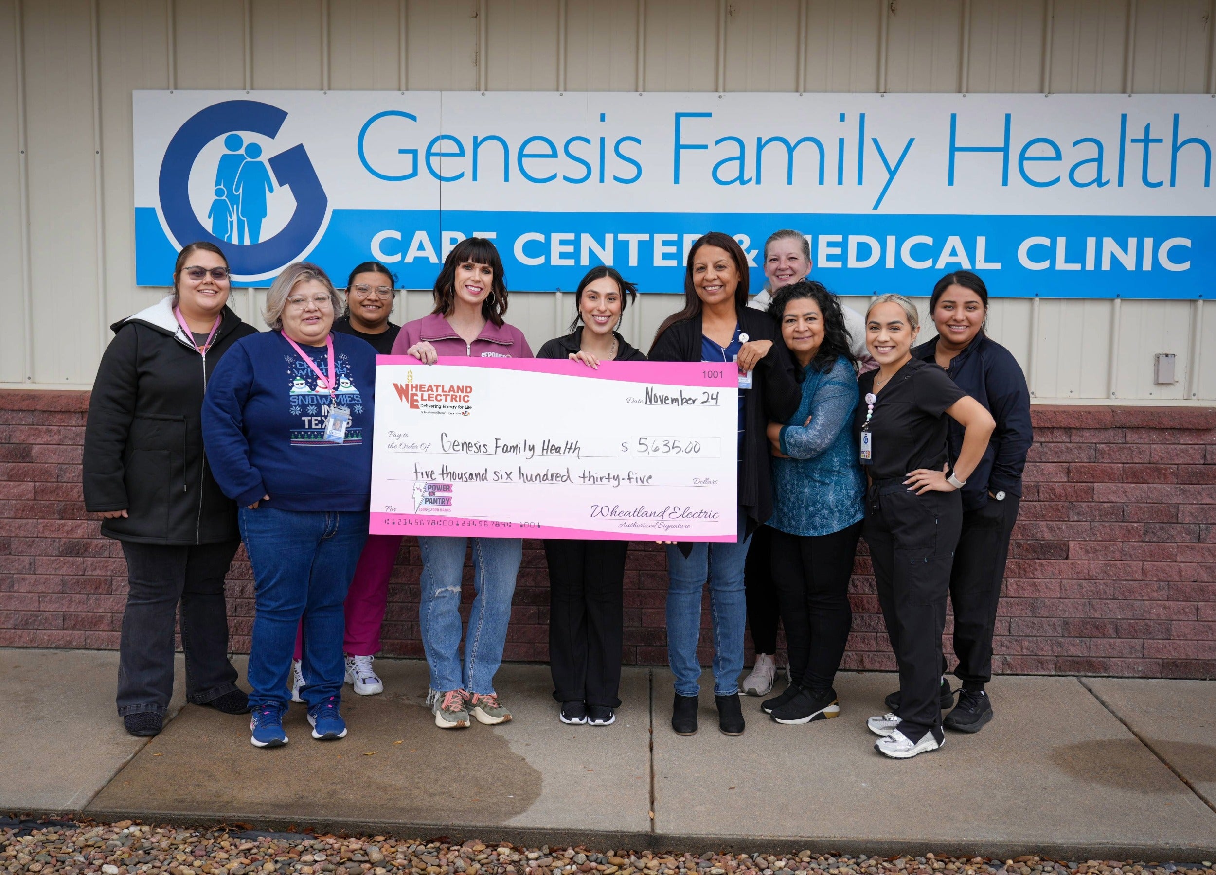 Alli Conine (fourth from left), director of member services and corporate communications at Wheatland Electric, presents a check for $5,635 to staff members at Genesis Family Health in Garden City.