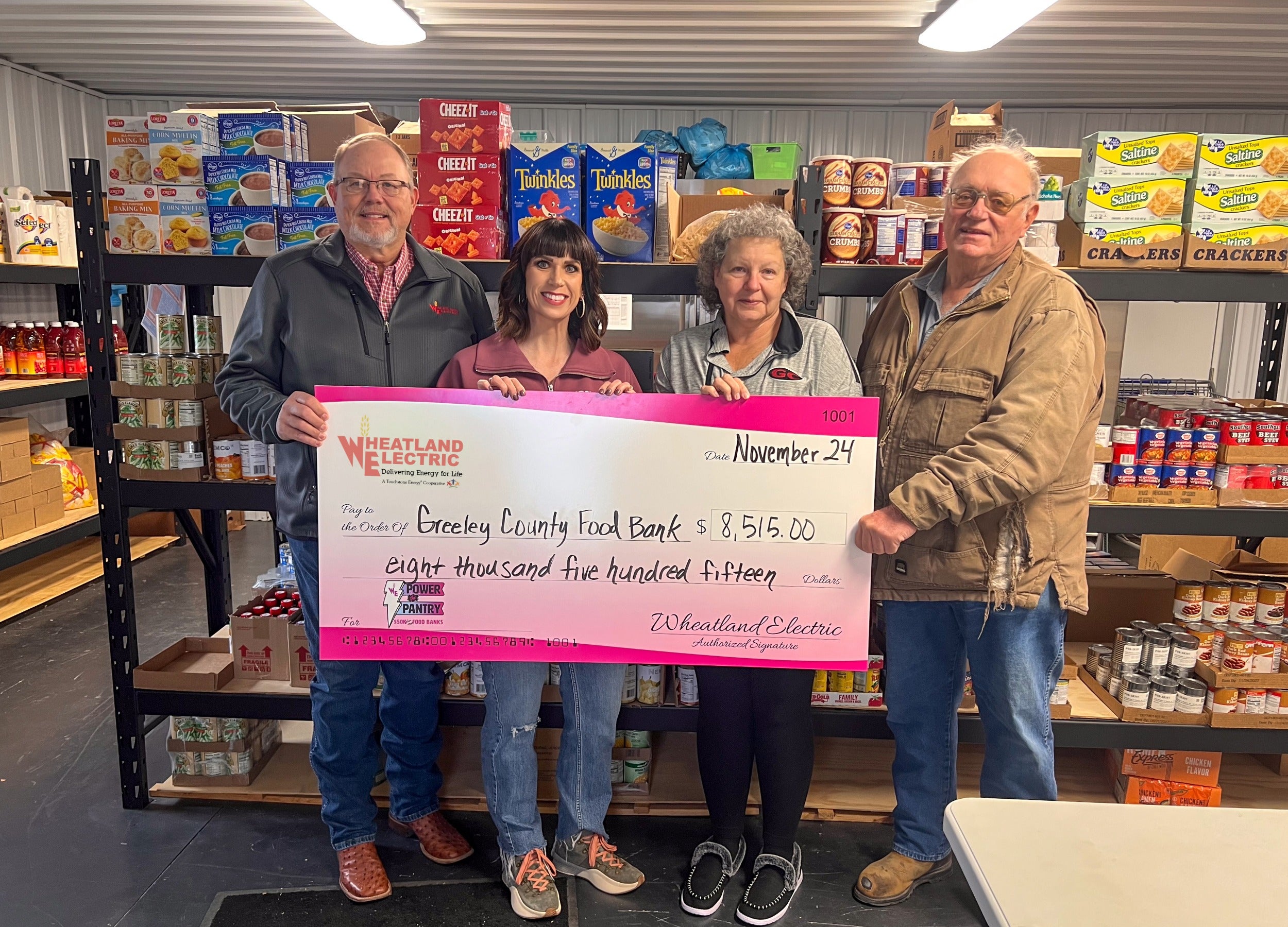 Representatives of Wheatland Electric (from left) Kevin White, trustee, and Alli Conine, director of member services and corporate communications, present a check for $8,515 to representatives of the Greeley County Food Bank, including Kathleen Downing (second from left).
